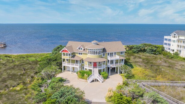A large, multi-story building with a prominent balcony and a circular tower, situated near a body of water. - Soundfront with Private Pool, Hot Tub, Elevator, Private Sound Access, Game Room (Avon)