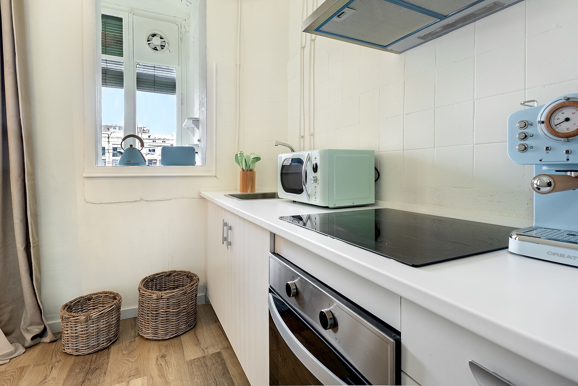 Una kitchenette compacta con microondas, tostadora y horno.