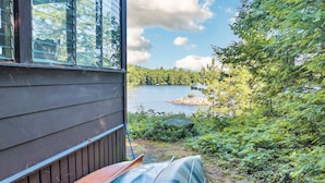 Een huis met uitzicht op een meer en bos.
