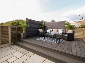 A patio area with a sofa set, a table, and potted plants.
