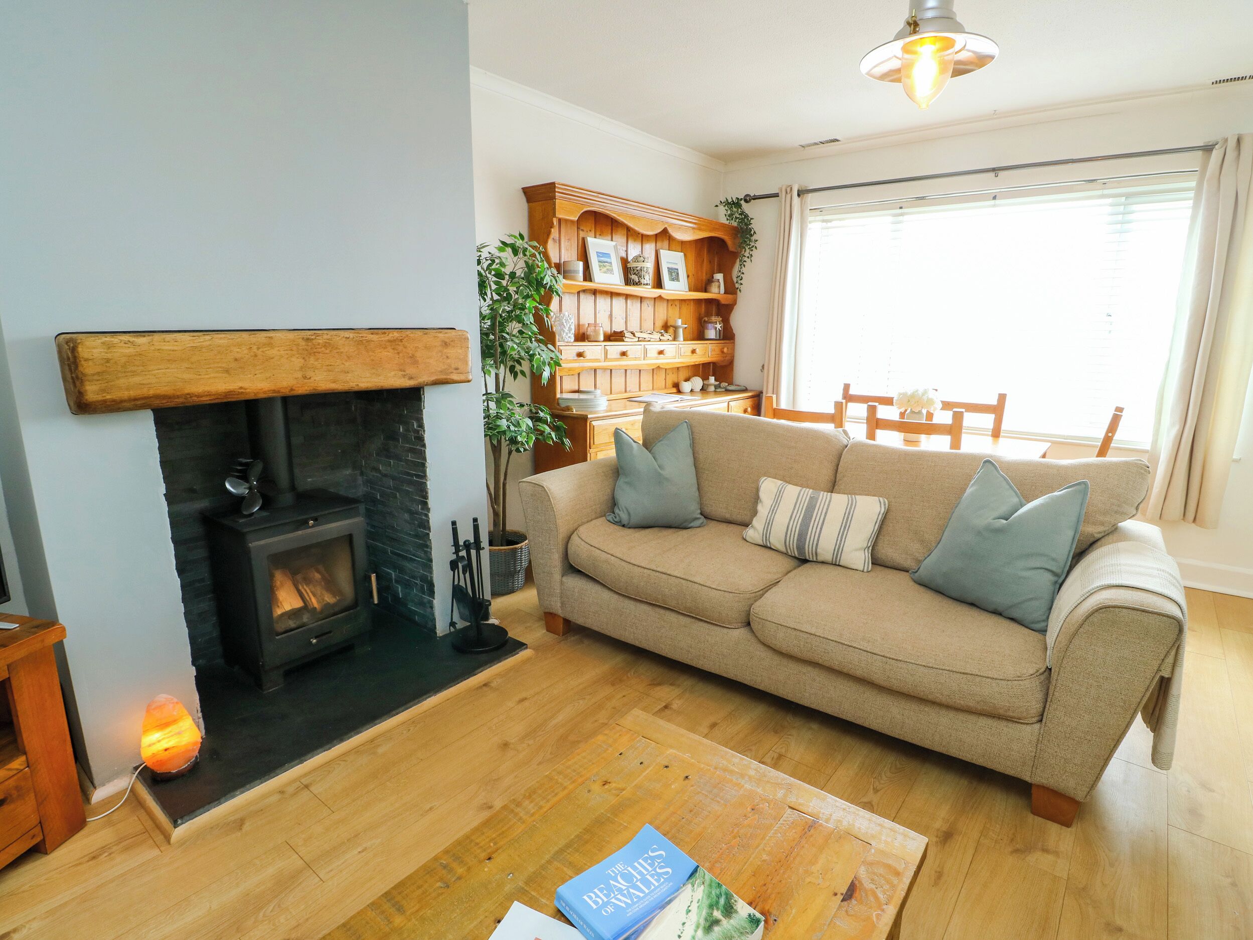 A living room with a fireplace, a sofa, a coffee table, and a bookshelf.