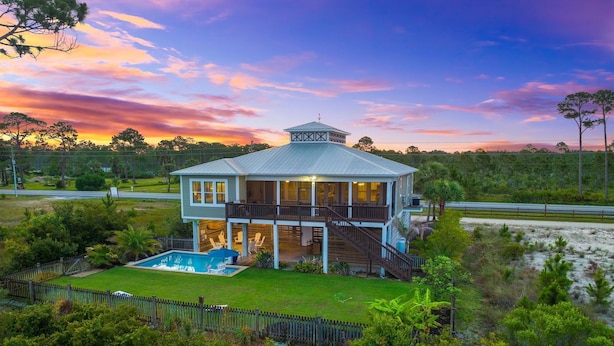 A two-story house with a large deck and a swimming pool. - Relax by the Pool, Enjoy Bayfront Views (Port St. Joe)