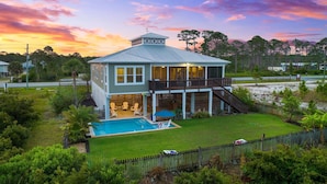 A two-story house with a covered porch, a swimming pool, and a fenced yard. - Relax by the Pool, Enjoy Bayfront Views (Port St. Joe)