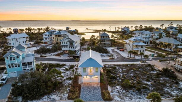 Une zone résidentielle côtière comprenant plusieurs maisons, un quai et une plage.