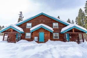 Une cabane en bois avec un toit turquoise et une enseigne sur laquelle on peut lire « BLUE BUCKET ».