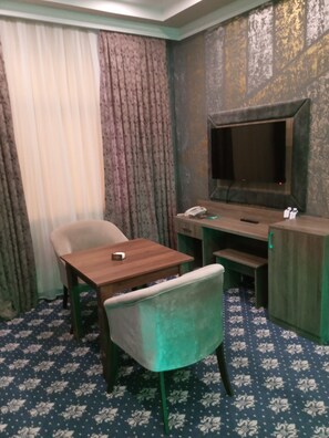 أغطية فراش متميزة وميني بار وخزنة داخل الغرفة ومكتب