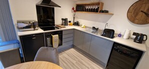 A compact kitchen with a built-in oven, a dishwasher, and a coffee maker.