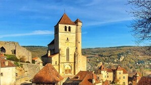 Una città storica con una chiesa importante caratterizzata da un alto campanile, circondata da edifici tradizionali con tetti spioventi.