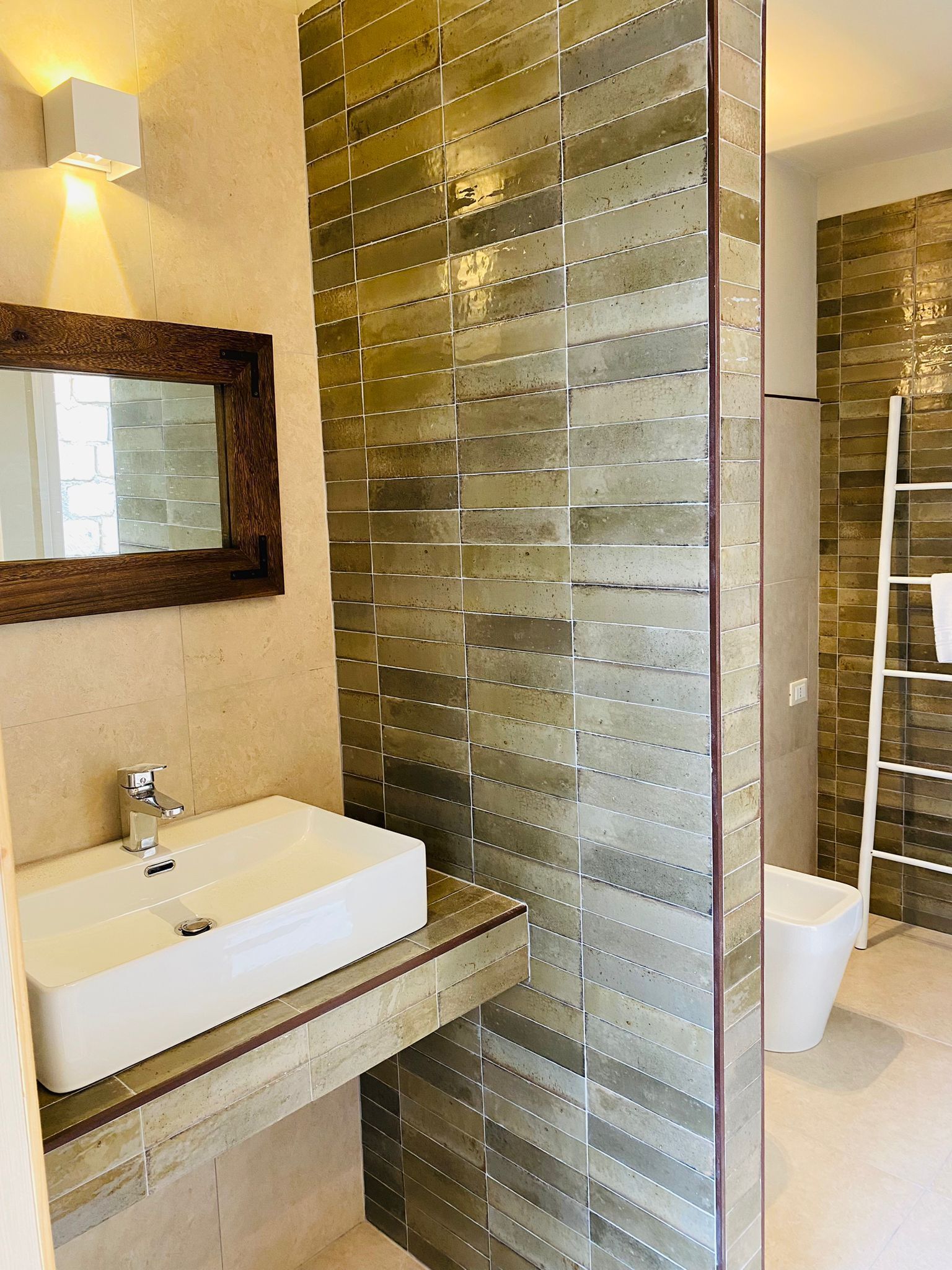 A bathroom with a white sink, a mirror, and a shower area with a glass door.