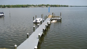 A pier extending into a calm lake with boats docked at the end. - The "Dock House" (Edgewood)