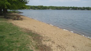 A lakeside beach with picnic tables and a tree. - The "Dock House" (Edgewood)