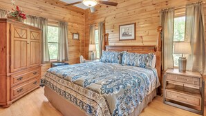 A wooden-paneled bedroom with a bed, nightstands, a dresser, and a ceiling fan. - Heavenly Views - Amazing Mountain Views 8 Bedroom Cabin by Heavenly Views Resort (Gatlinburg)