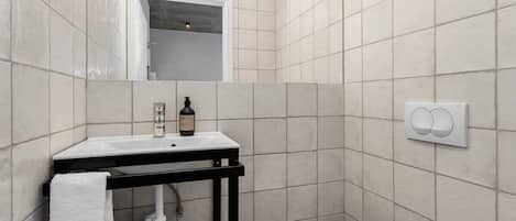 A bathroom with a white sink, a mirror, and a toilet.