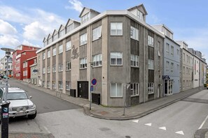 A multi-story building with a corner entrance, a visible door, and a sign indicating no parking. - Swan Double Studio for 2 (Reykjavík)