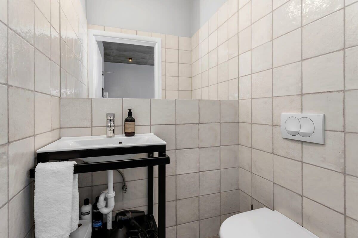 A bathroom with a white sink, a mirror, and a toilet.