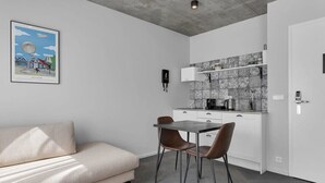 Eine moderne Küche mit weißen Schränken, einer gefliesten Spritzschutzwand und einem Essbereich mit Tisch und Stühlen.