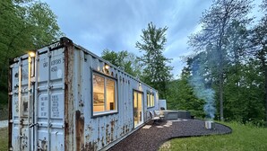 A rustic, container-style building with a gravel path leading to it, surrounded by trees. - THIS IS THE ONE! SHIPPING CONTAINER CABIN-VIEW-WIFI-NATURAL BRIDGE-NADA TUNNEL (Stanton)