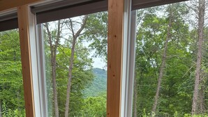 A room with a wooden desk and two stools, large windows with a view of trees and hills. - THIS IS THE ONE! SHIPPING CONTAINER CABIN-VIEW-WIFI-NATURAL BRIDGE-NADA TUNNEL (Stanton)