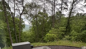 A hot tub with a view of a forested area. - THIS IS THE ONE! SHIPPING CONTAINER CABIN-VIEW-WIFI-NATURAL BRIDGE-NADA TUNNEL (Stanton)