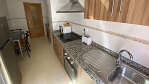 Eine Küche mit Granit Arbeitsplatten, einer Edelstahl-Spüle, einer Mikrowelle und einem Toaster.