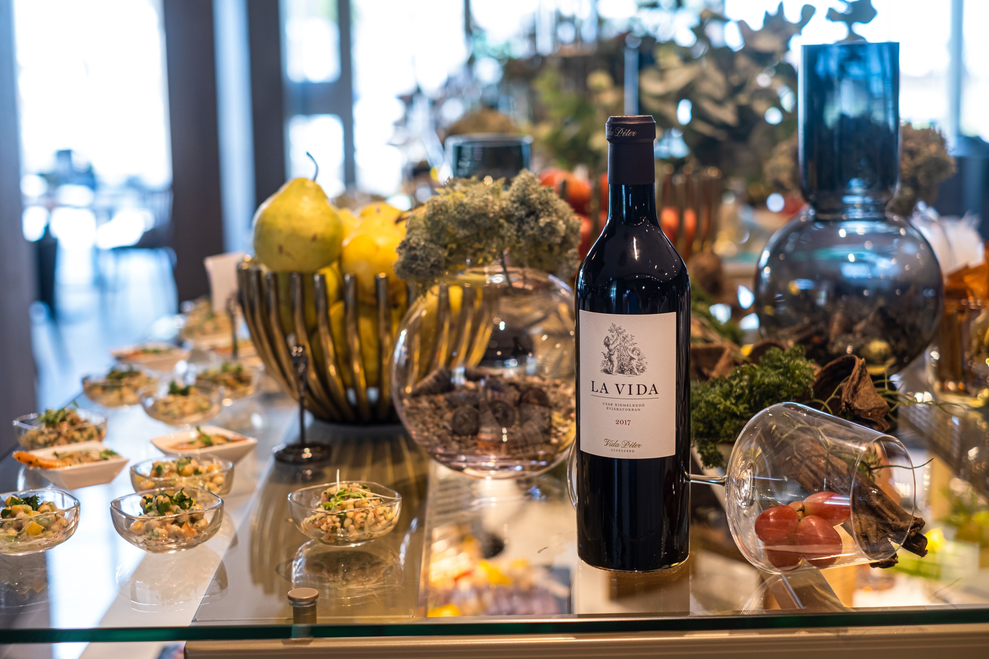 A table with various food items and a bottle of wine.
