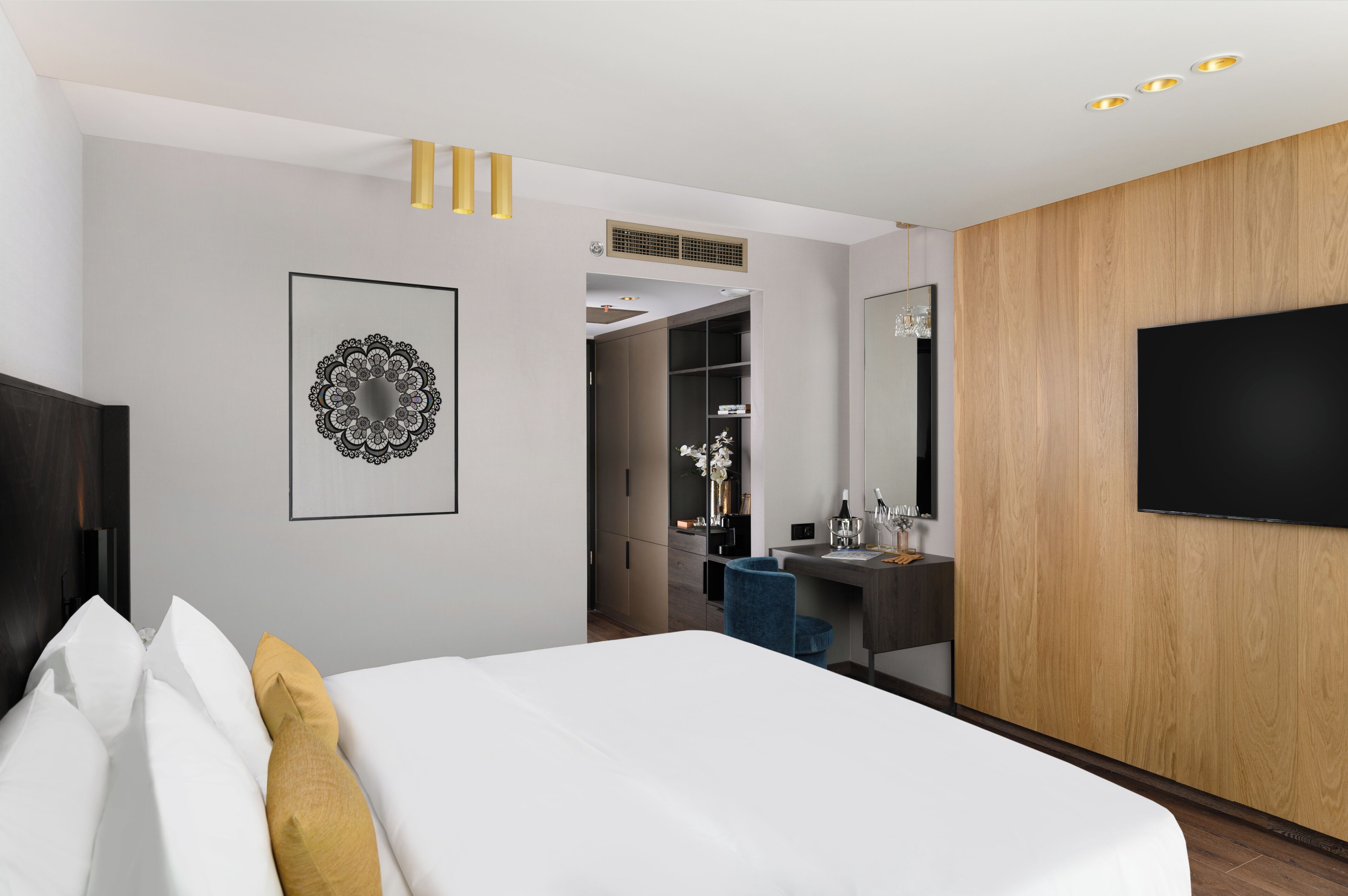 Une chambre d’hôtel moderne équipée d’un lit, d’un bureau, d’une armoire et d’un téléviseur.