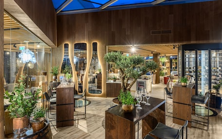 A modern interior with wooden accents, glass partitions, and indoor plants.
