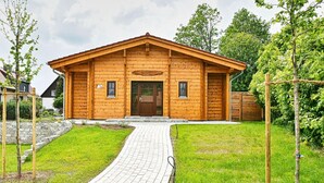 Puinen rakennus, jossa on kalteva katto, etuovi ja pieni ikkuna sivulla.
