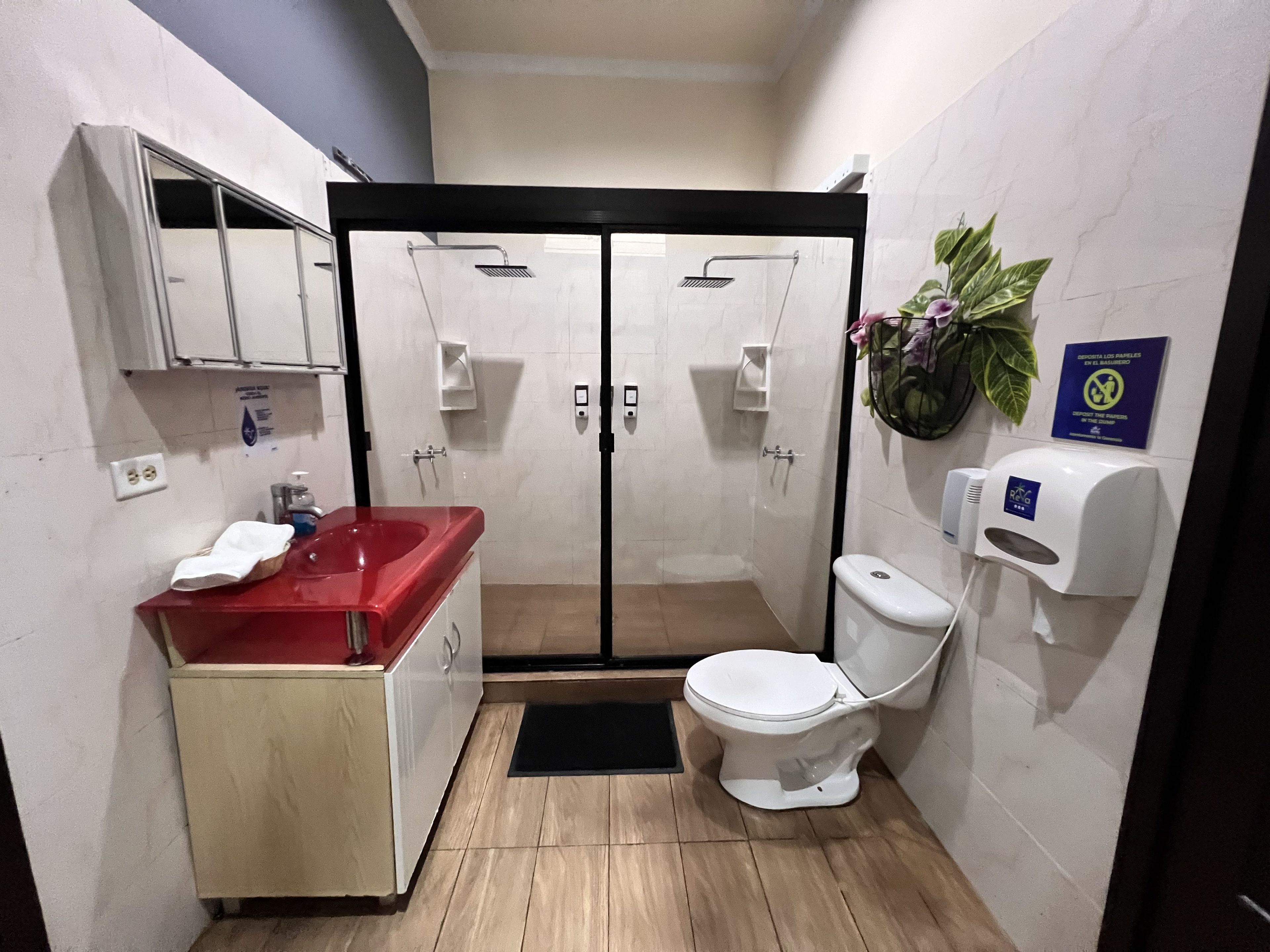 Un baño pequeño con cabina de ducha, lavamanos e inodoro.