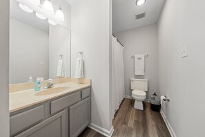 Ein Badezimmer mit Waschbecken, Spiegel und Toilette.
