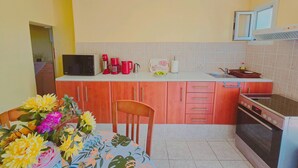 A kitchen with a microwave, coffee maker, and toaster on the counter, a sink, and an oven. - Fully furnished tranquil apartment in Zakynthos (Lithakia)