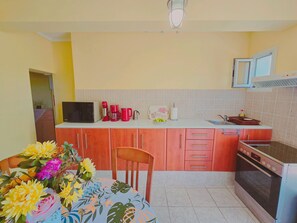 A kitchen with a microwave, coffee maker, and toaster on the counter, a sink, and an oven. - Fully furnished tranquil apartment in Zakynthos (Lithakia)