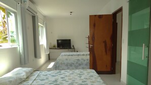 A room with two beds, a television, and a green door. - Recanto Feliz (Tamandaré)