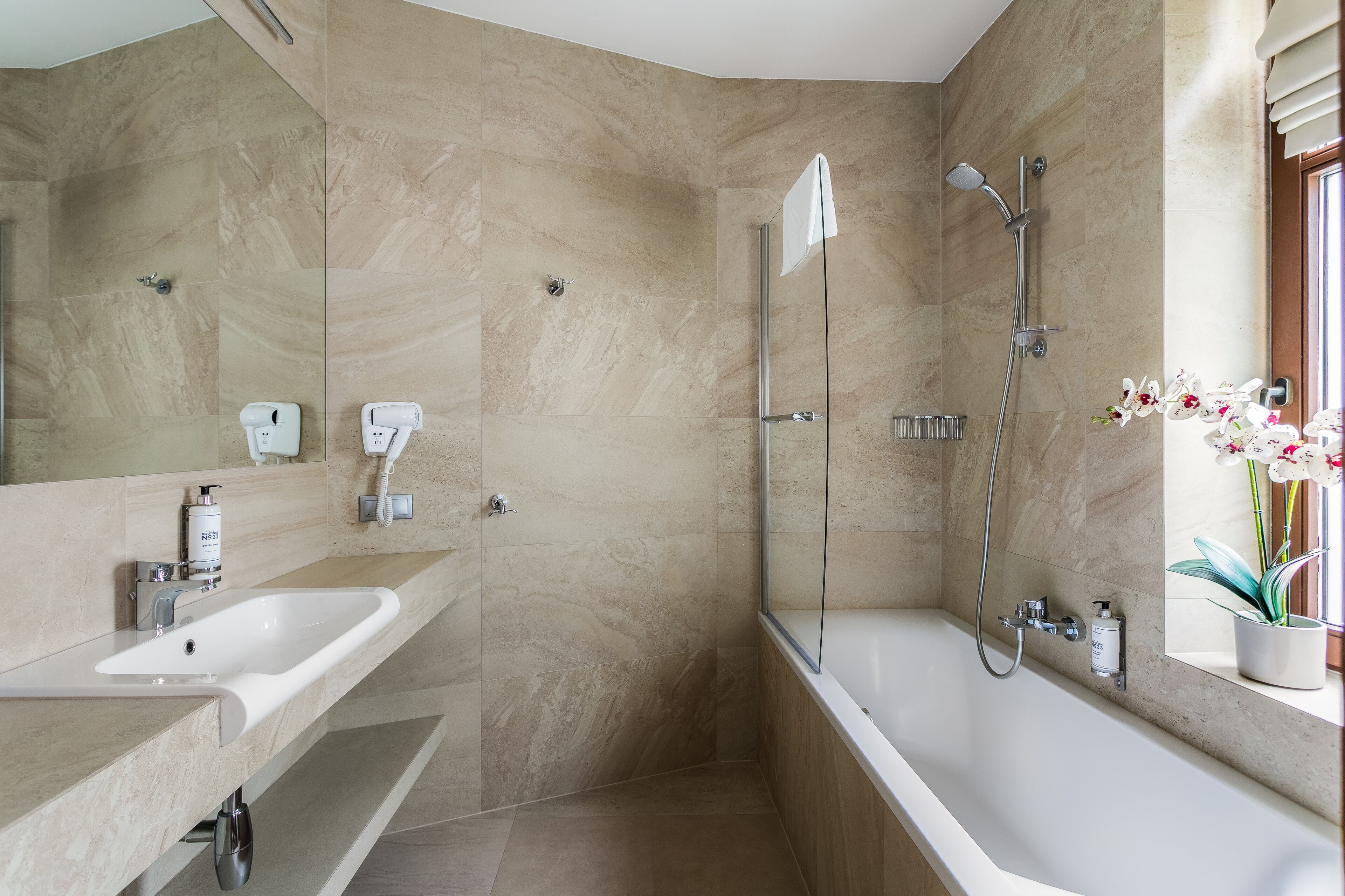 Une salle de bain moderne avec un grand lavabo, une baignoire et un espace douche.