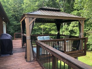 A wooden deck with a gazebo, outdoor furniture, and a grill. - Cozy house in private Leesville Lake community (Pittsville)