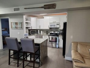 Enjoy cooking in this well-equipped kitchen with a microwave, oven, and toaster, and dine at the adjacent island with bar stools.