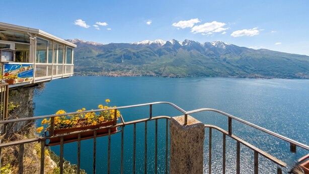 A balcony with a view of a lake and mountains.