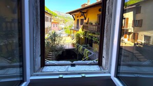 A window view of a town with buildings, a street, and a mountain in the background.