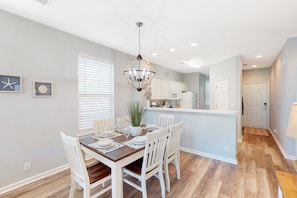 Enjoy meals in this stylish kitchen and dining area, featuring a central island, appliances, and a dining table for four.