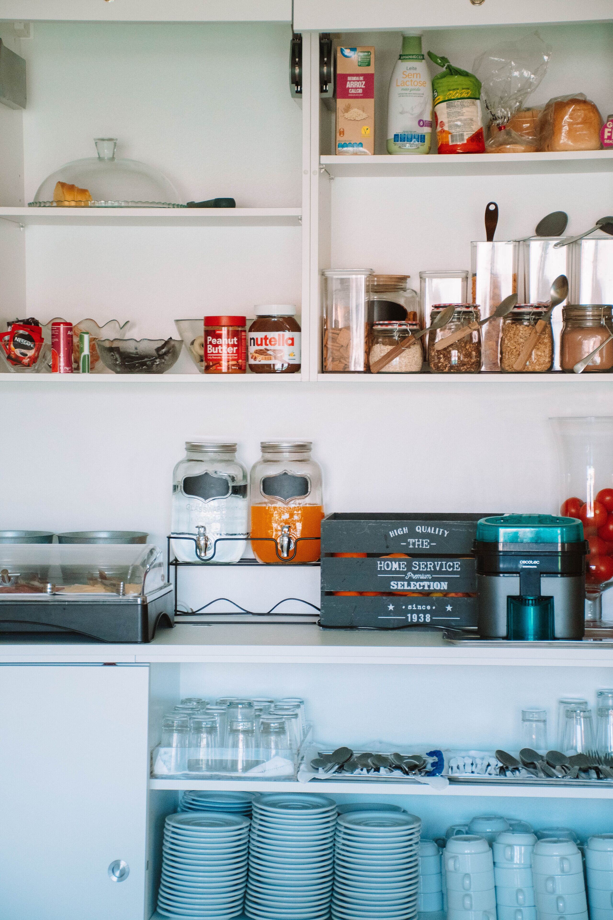 A kitchen with various food items, utensils, and appliances.