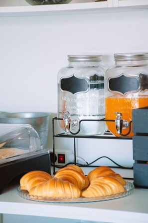 A kitchen counter with two glass jars labeled "GlacierWare" and a metal rack holding croissants. - ARCA NOVA GUEST HOUSE & HOSTEL (Caminha)