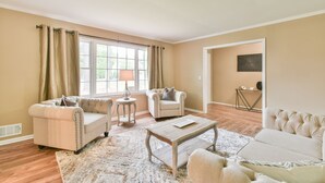 A spacious living room with a large window, two sofas, a coffee table, and a rug.