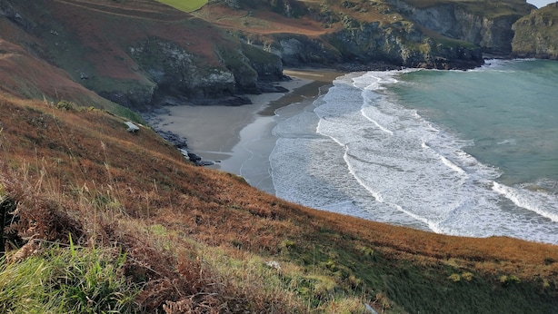 Eine Küstenlandschaft mit Klippen, einem Strand und einer felsigen Küstenlinie.