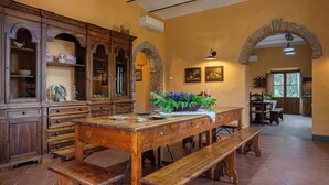 A dining area with a wooden table, benches, and a potted plant. - Belvedere - Ambra By Geco Vacation Rentals (Bucine)