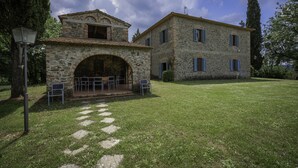 A stone building with a central archway and a patio with outdoor seating. - Belvedere - Ambra By Geco Vacation Rentals (Bucine)