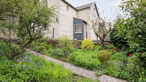 A house with a small garden, a visible door, and a window. - Myrtle Villa (Knighton)