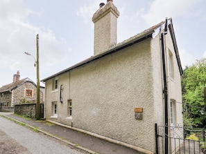 A stone building with a chimney, a small window, and a door.