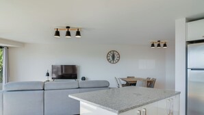 A modern kitchen with a grey countertop, a built-in oven, and a stainless steel refrigerator. - Banana Tree (Camara de Lobos)