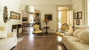 A spacious living room with a large window, a dining area, and a library. - Villa Manfredi by Wonderful Italy (Fasano)