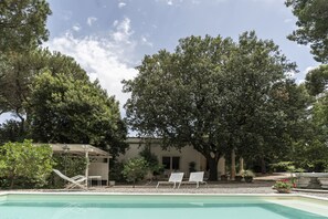 Relax by the tranquil pool surrounded by lush greenery and mature trees.